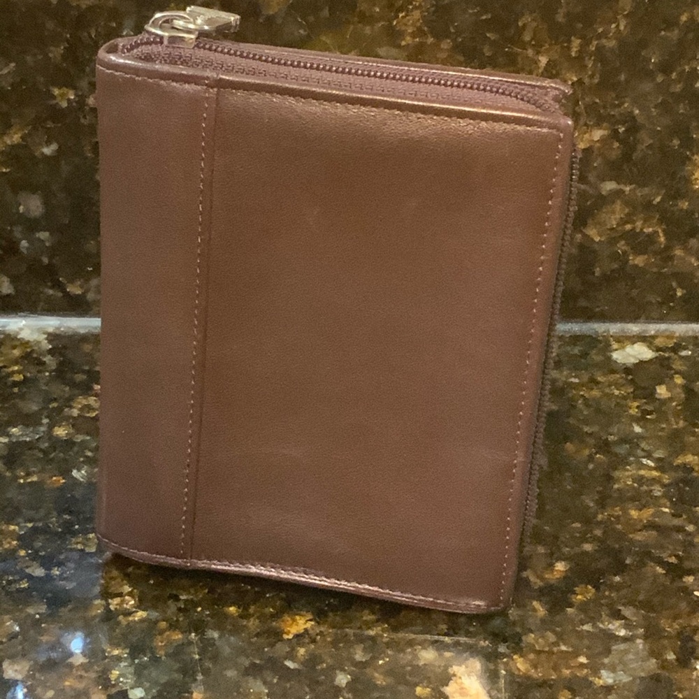 Tumi brown leather card case w/ zip around and 7 compartments.
